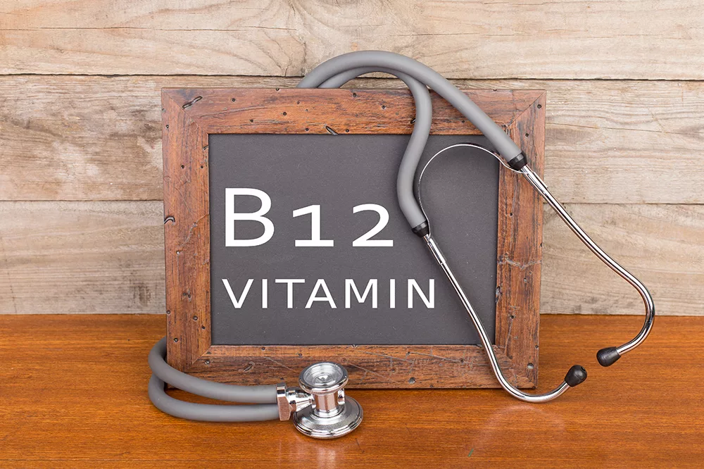 Medical concept - stethoscope and blackboard with text "Vitamin B12" on wooden background