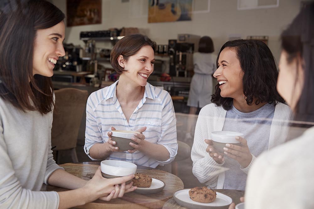 Four female friends relaxing over coffee at a coffee shop